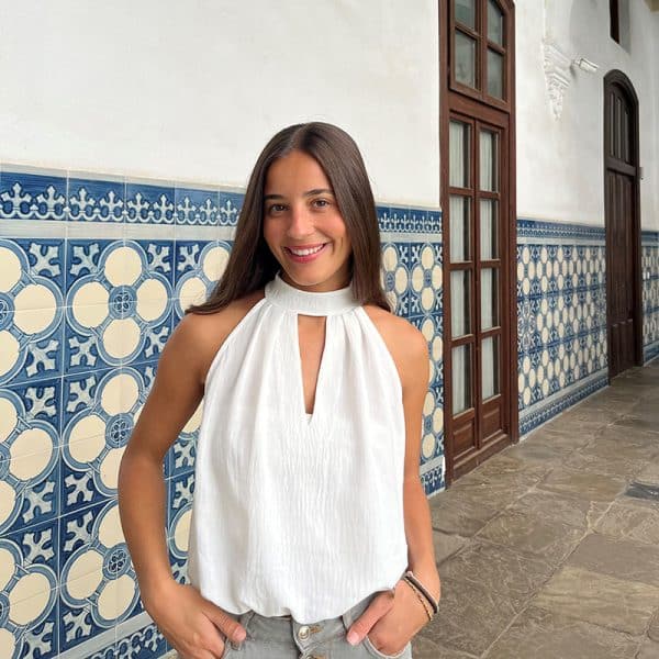 chica posando con blusa blanca sin mangas