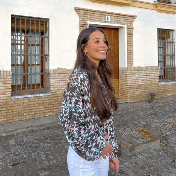 chica sonriendo con una blusa corta estampada con raja en hombros y manga larga