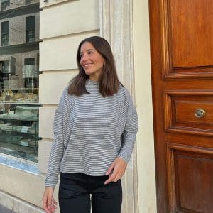 chica sonriendo con una camiseta oversize gris con rayas negras