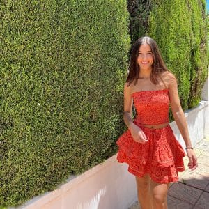 chica en la calle con un conjunto de top y falda de color coral