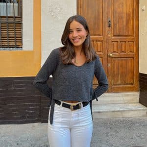 chica sonriendo con jersey cuello pico corto gris antracita con aberturas laterales con tiras para atar