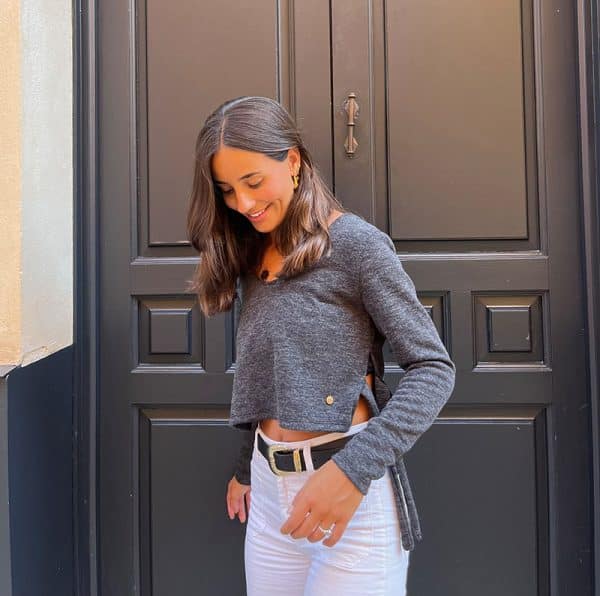 chica sonriendo con jersey cuello pico corto gris antracita con aberturas laterales con tiras para atar