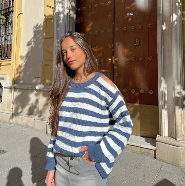 chica con un jersey con hombros descubiertos de rayas azules y blancas