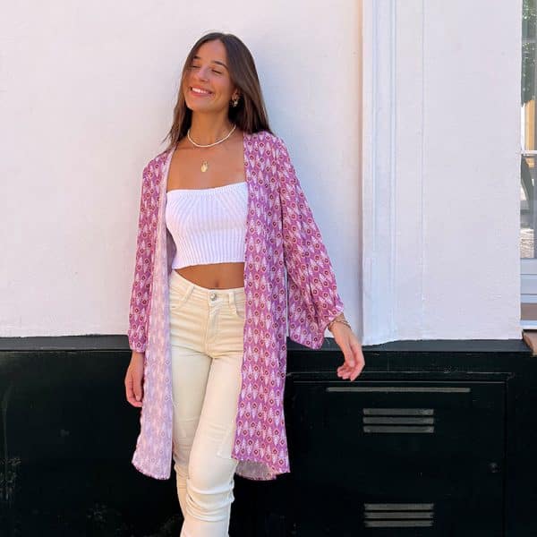 chica apoyada en pared blanca con un kimono estampado