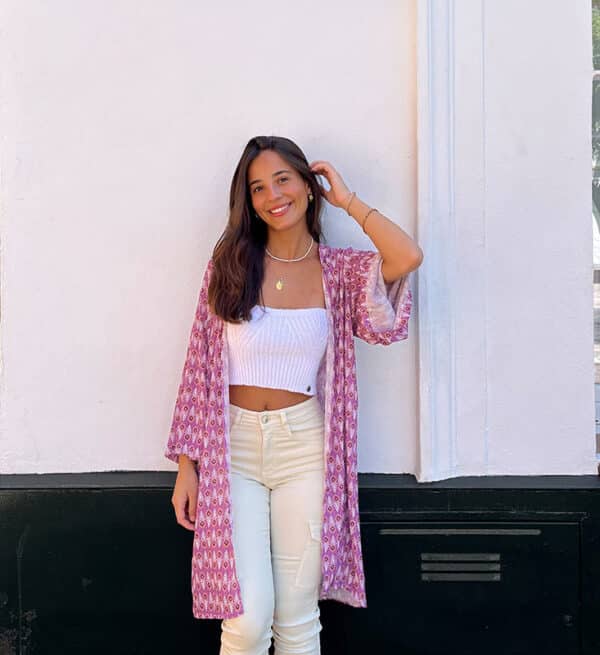 chica apoyada en pared blanca con un kimono estampado