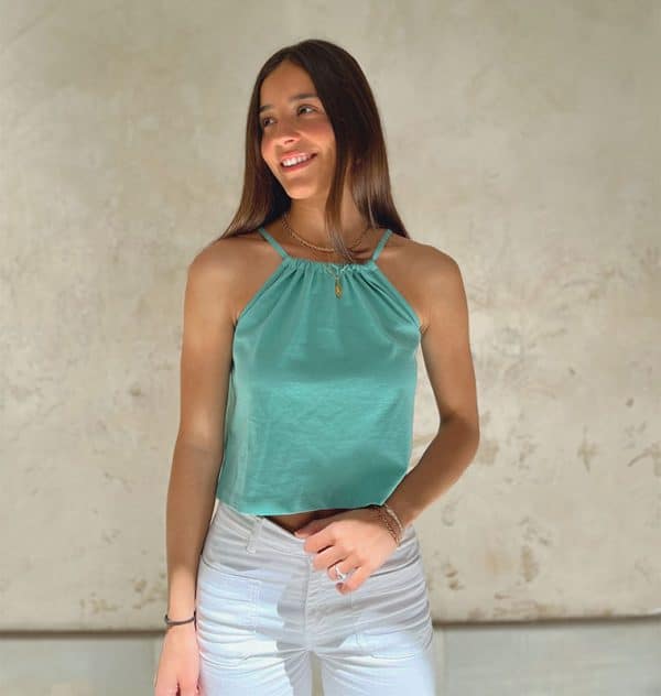 chica sonriendo con top halter color verde wasabi