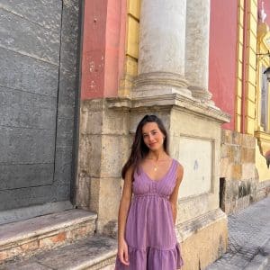 chica en la calle con vestido playero de color rosa viejo