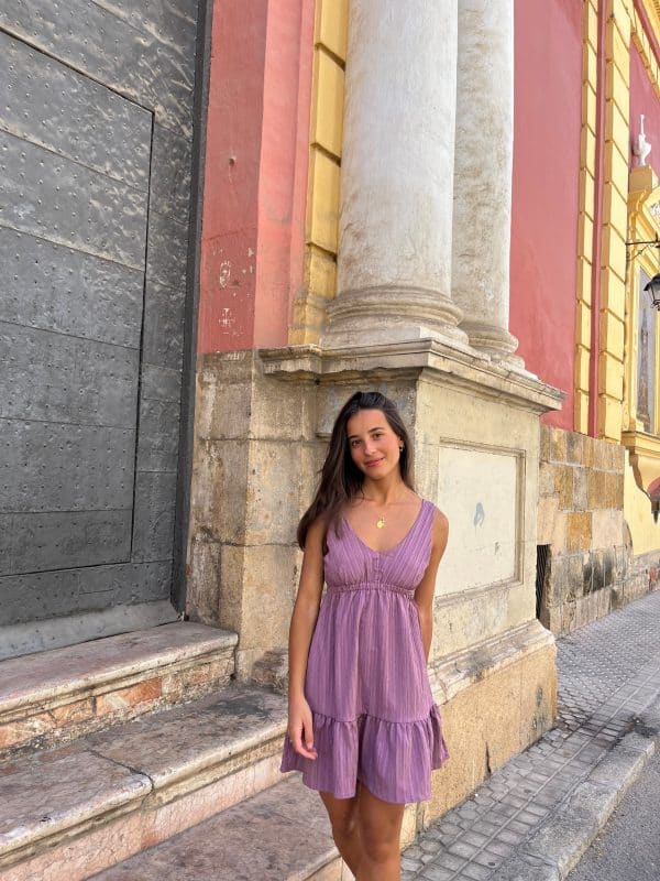 chica en la calle con vestido playero de color rosa viejo