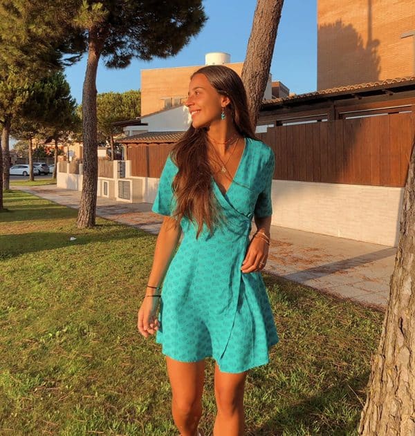 chica con un vestido corto verde cruzado estampado